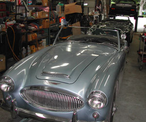 60 Austin Healey leading a row of cars in the bay waiting for work